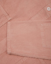 Close-up shot of pale pink, buttoned corduroy overshirt from Uskees. Showing sleeve detail and corozo buttons, 