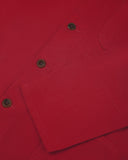 Closer view of mid section of berry red, buttoned organic cotton overshirt from Uskees. Focus on cuff, placket and corozo buttons.
