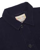 Close-up view of 3001 midnight blue, buttoned corduroy overshirt from Uskees showing corozo buttons, brand/size label, collar and hanging hoop.
