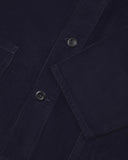 Closer view of mid section of midnight blue, buttoned corduroy overshirt from Uskees. Focus on cuff, pockets, corozo buttons and corduroy texture.