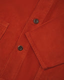 Closer view of mid section of rust-red, buttoned corduroy overshirt from Uskees. Focus on cuff, pockets, corozo buttons and corduroy texture.