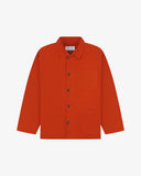 Front flat view of deep orange shirt-jacket showing the collar, Uskees brand label and 3 front pockets on a white background