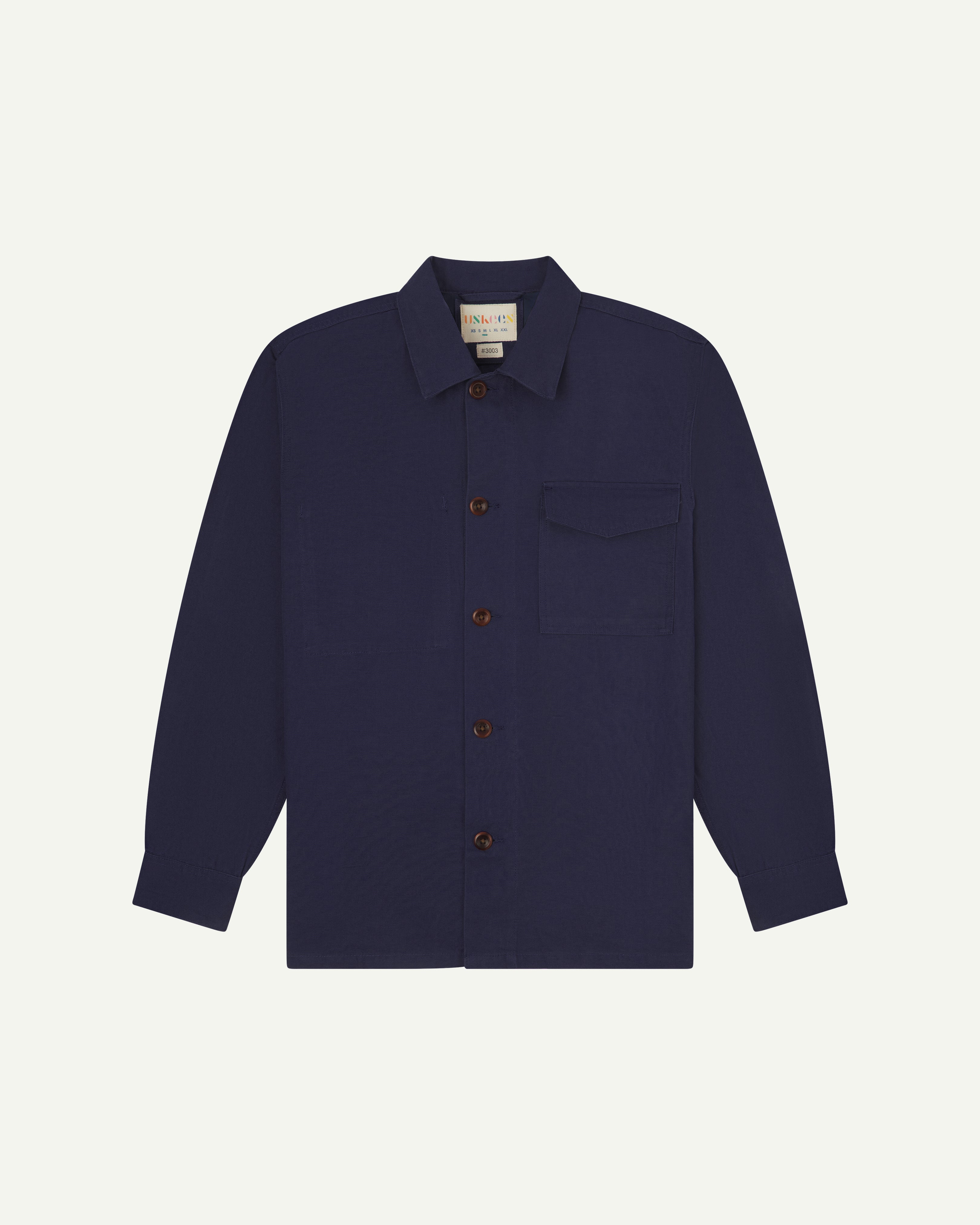 Front flat shot of dark blue #3003 workshirt from Uskees. Showing chest pocket with flap and corozo buttons.