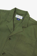 Angled top-half view of #3006, coriander-green organic cotton-twill blazer. With focus on collar, lapels, breast pocket, Uskees brand label and corozo buttons.