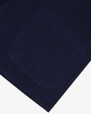 Close-up of a navy blue cord blazer showing the pocket detail, presented on a white background
