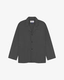 Charcoal-grey buttoned organic cotton-drill blazer from Uskees with clear view of three patch pockets and Uskees branding label.