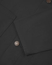 Close view of uskees dark grey canvas men's shacket showing the cuff/sleeve and metal buttons..