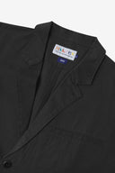 Close-up and angled front view of the 3047 docklands blazer showing the twill fabric texture, collar, lapel, Uskees branding label and jetted breast pocket.