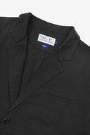 Close-up and angled front view of the 3047 docklands blazer showing the twill fabric texture, collar, lapel, Uskees branding label and jetted breast pocket.