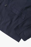 Close-up view of the cuff, jetted hip pocket and corozo buttons of the 3047 docklands blazer from Uskees. Also is a closer view of the texture of the deep blue organic cotton twill.