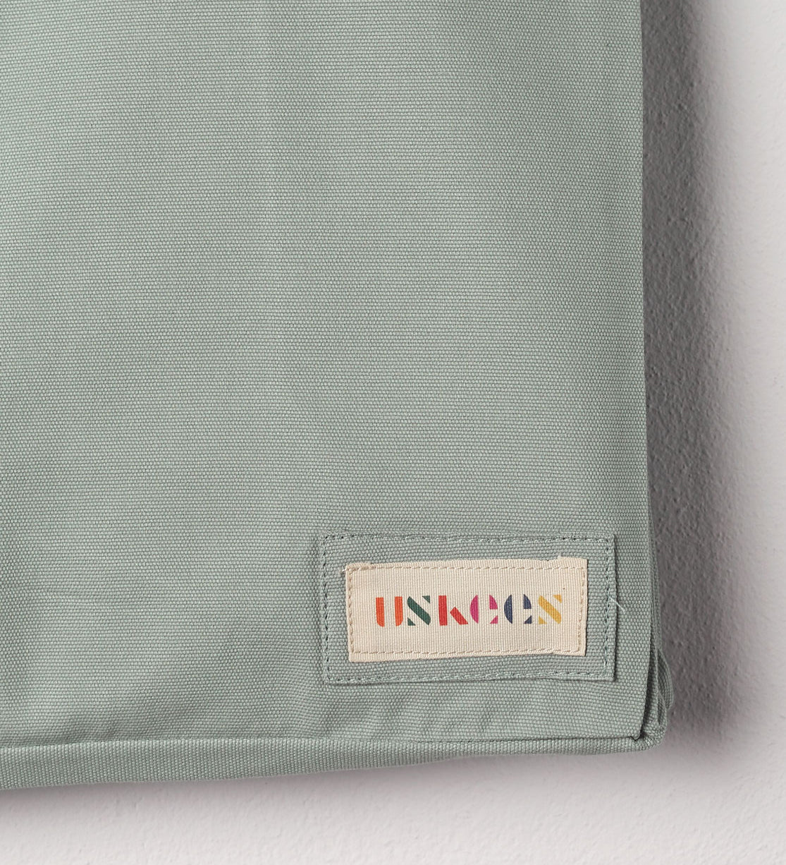 Close-up view of Uskees #4001 large tote bag in jade green showing the Uskees woven label.