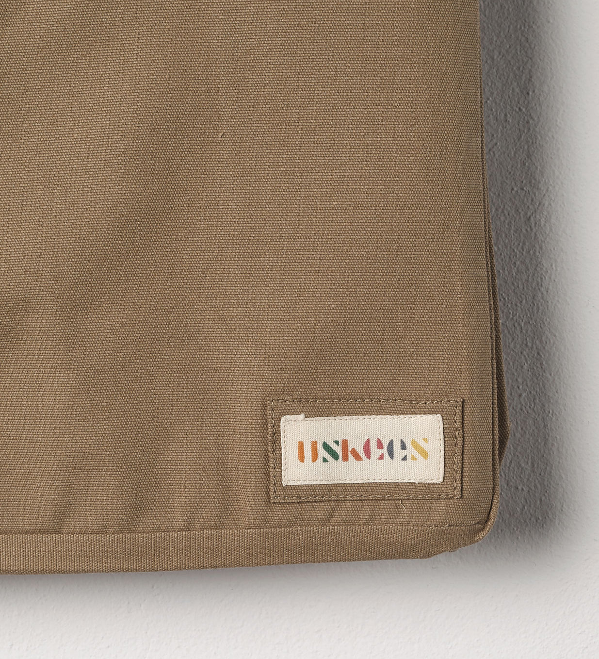 Close-up view of Uskees #4001 large tote bag in khaki showing the Uskees woven label.