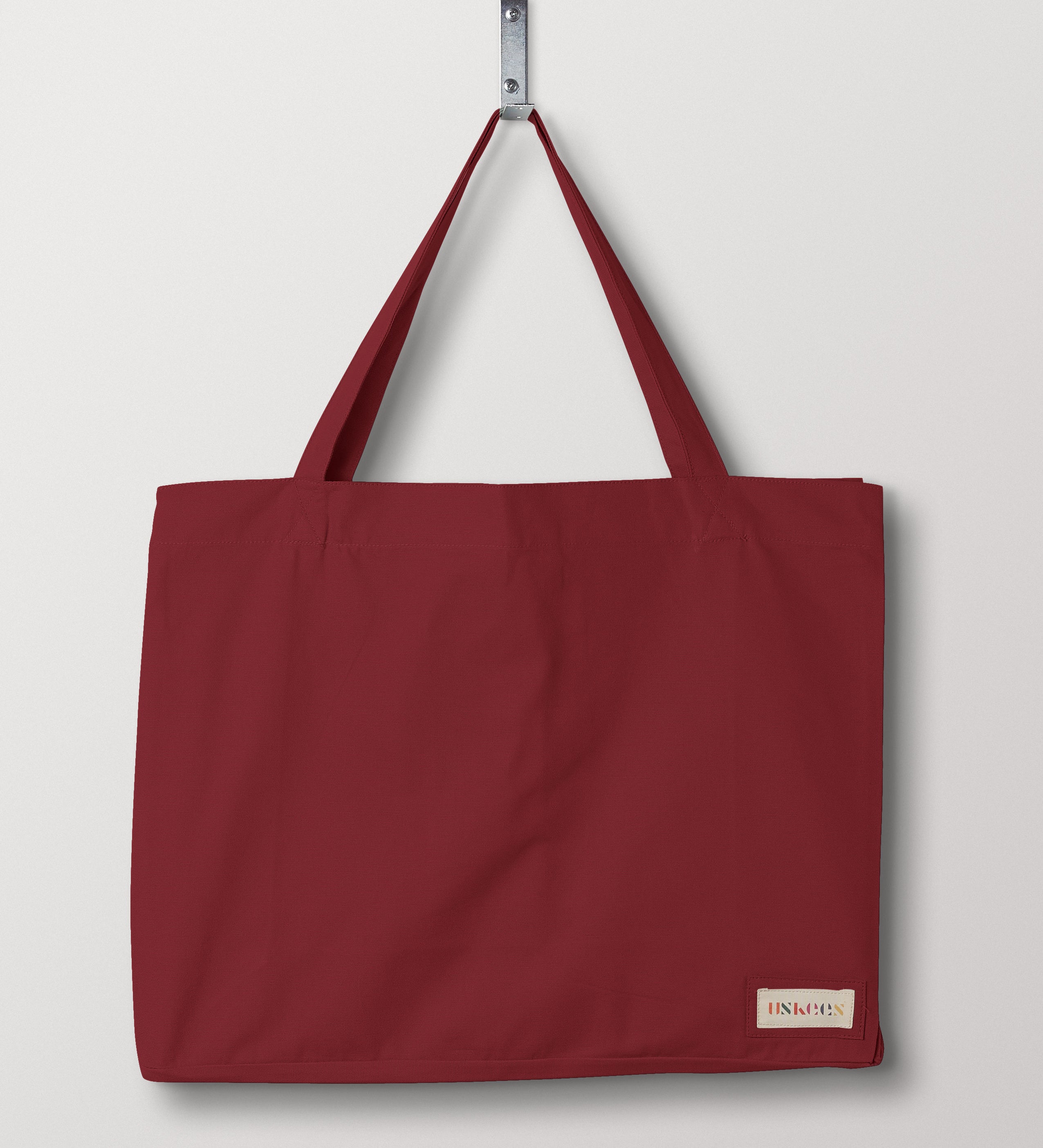 Full front flat shot of Uskees #4001, large 'merlot' coloured tote bag, showing double handles and Uskees woven logo.