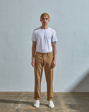 Full length front-view of model wearing khaki 5005 trousers with view of YKK zip fly and Corozo buttons. Paired with plain white t-shirt.
