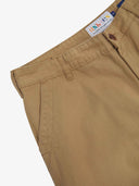 Close up of waist area of twill workwear pants in khaki. Clear view of front pocket, Corozo button fastening, Uskees branding label and organic cotton twill weave.