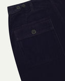 Close-up reverse view of Uskees midnight blue corduroy work pants with focus on left rear pocket, belt loops, triple stitching and adjustable button waist.