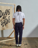 Full length back-view of model wearing faded black corduroy 5005 trousers with view of rear pockets and belt loops.