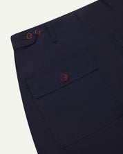 Back view of uskees #5005 men's trousers in dark blue showing buttoned back pocket and waist adjusting corozo buttons at waist.