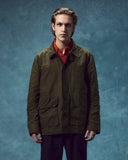 Front view of man wearing the Uskees wax storm jacket in dark 'Pennine' green.
