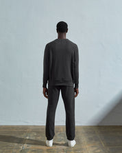 Full-length back view of model wearing faded black, relaxed cut organic cotton #7005 jersey sweatshirt with ribbed cuffs and hem.
