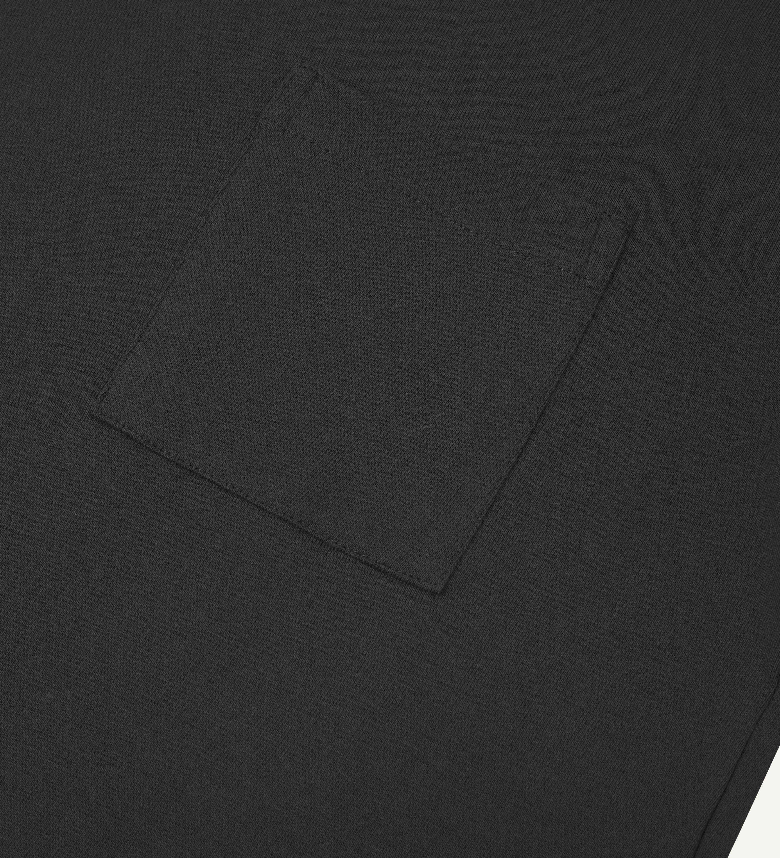 Close-up shot of Uskees #7010 long sleeve t-shirt in faded black showing front breast pocket