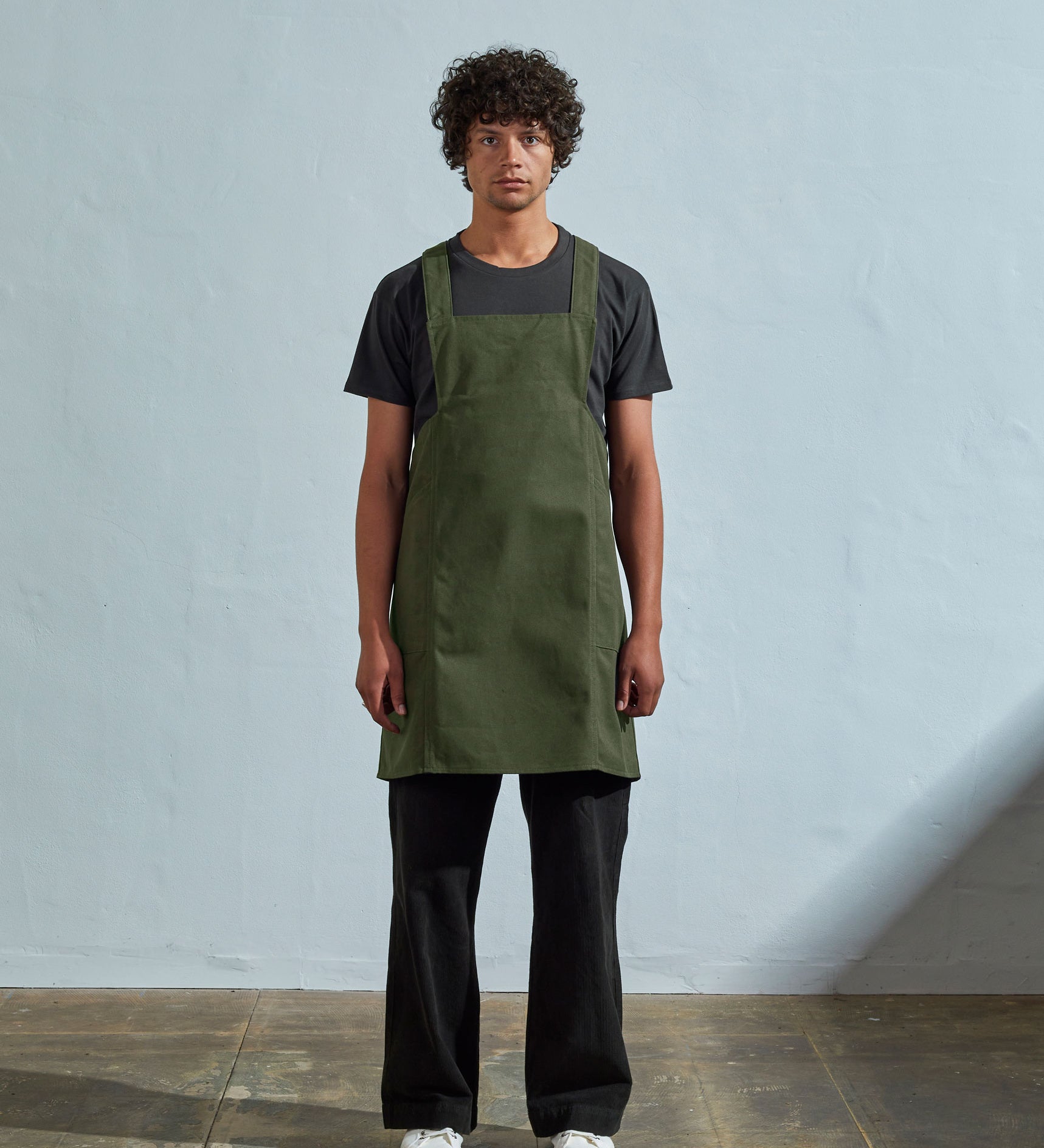 Full-length, front view of model wearing Uskees #9003 coriander-green Japanese style apron by Uskees.