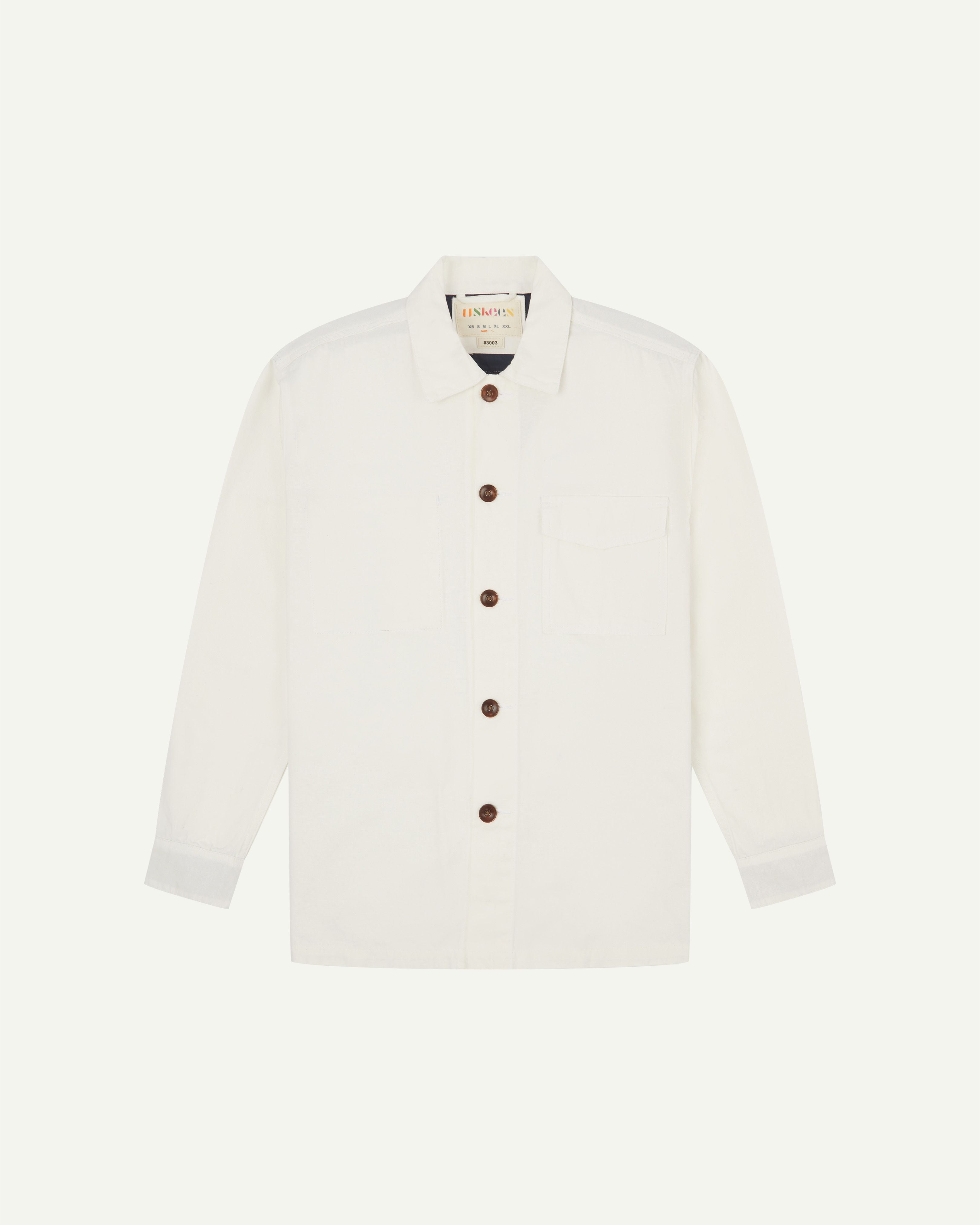 Front flat view of cream buttoned 3003 workshirt from Uskees. Showing breast pocket, navy yoke lining and brown corozo buttons