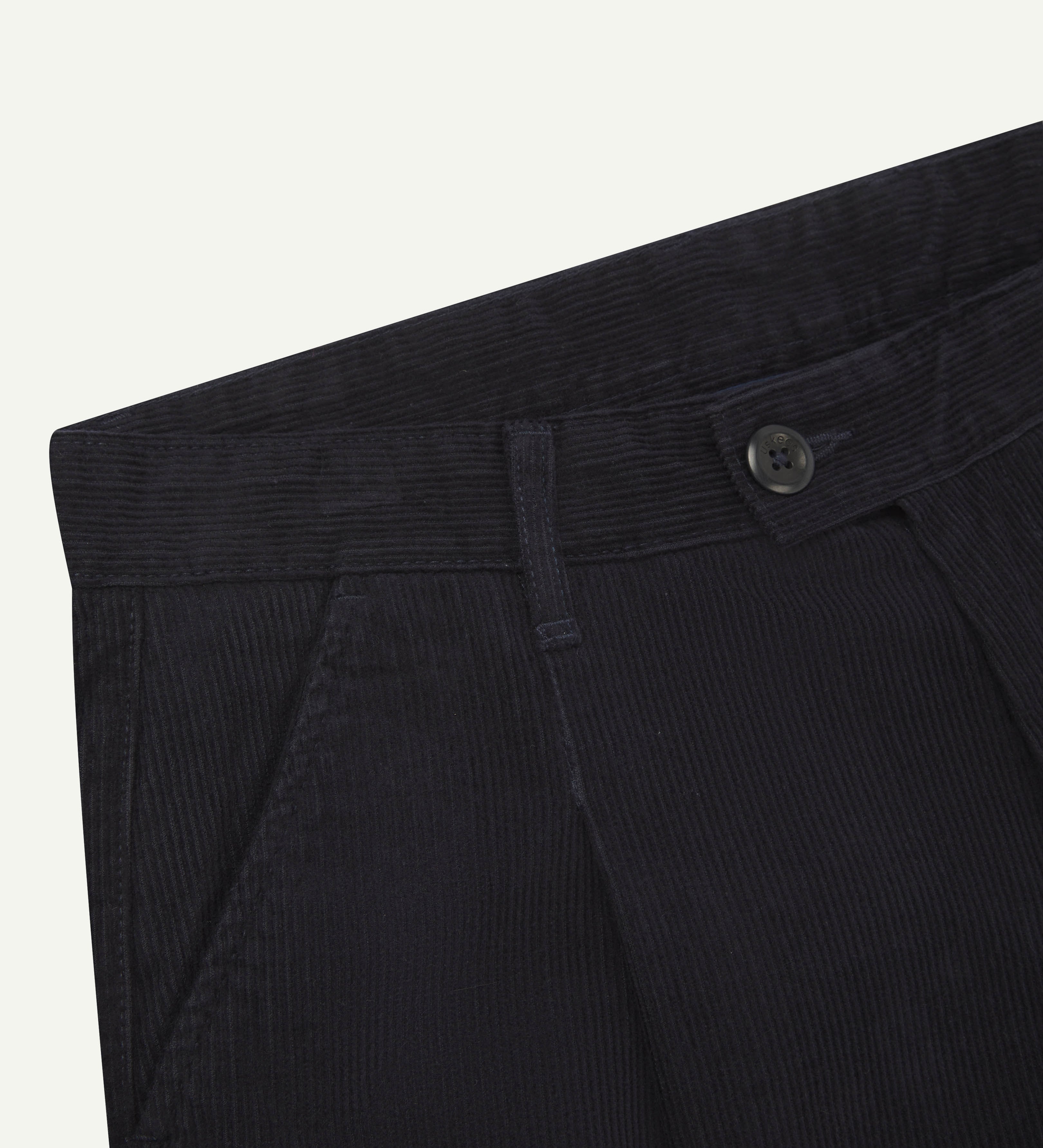 Front close-up shot of #5018 Uskees men's organic corduroy boat trousers in navy blue showing belt loop, buttoned waist and slanted front pocket.