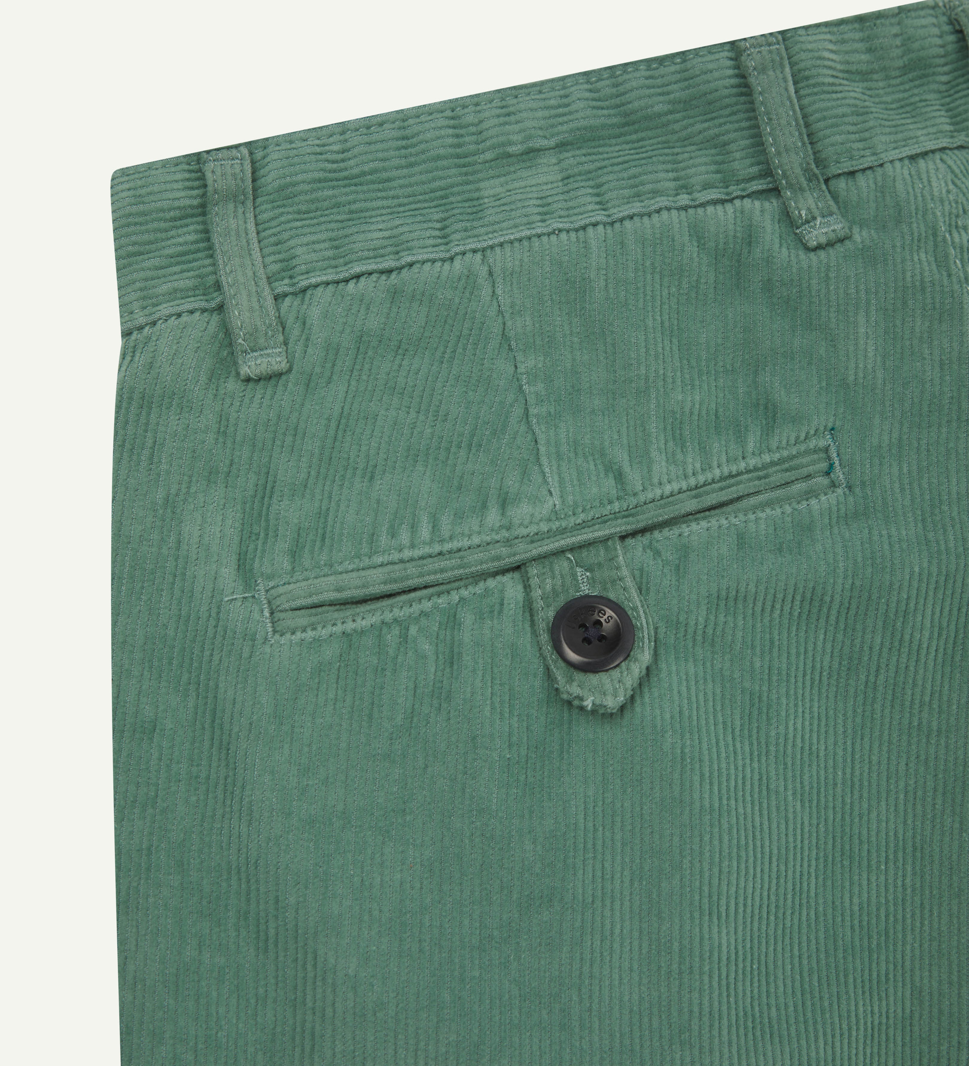 Back close-up shot of #5018 Uskees men's organic corduroy boat trousers in light green showing belt loops and buttoned back pocket.