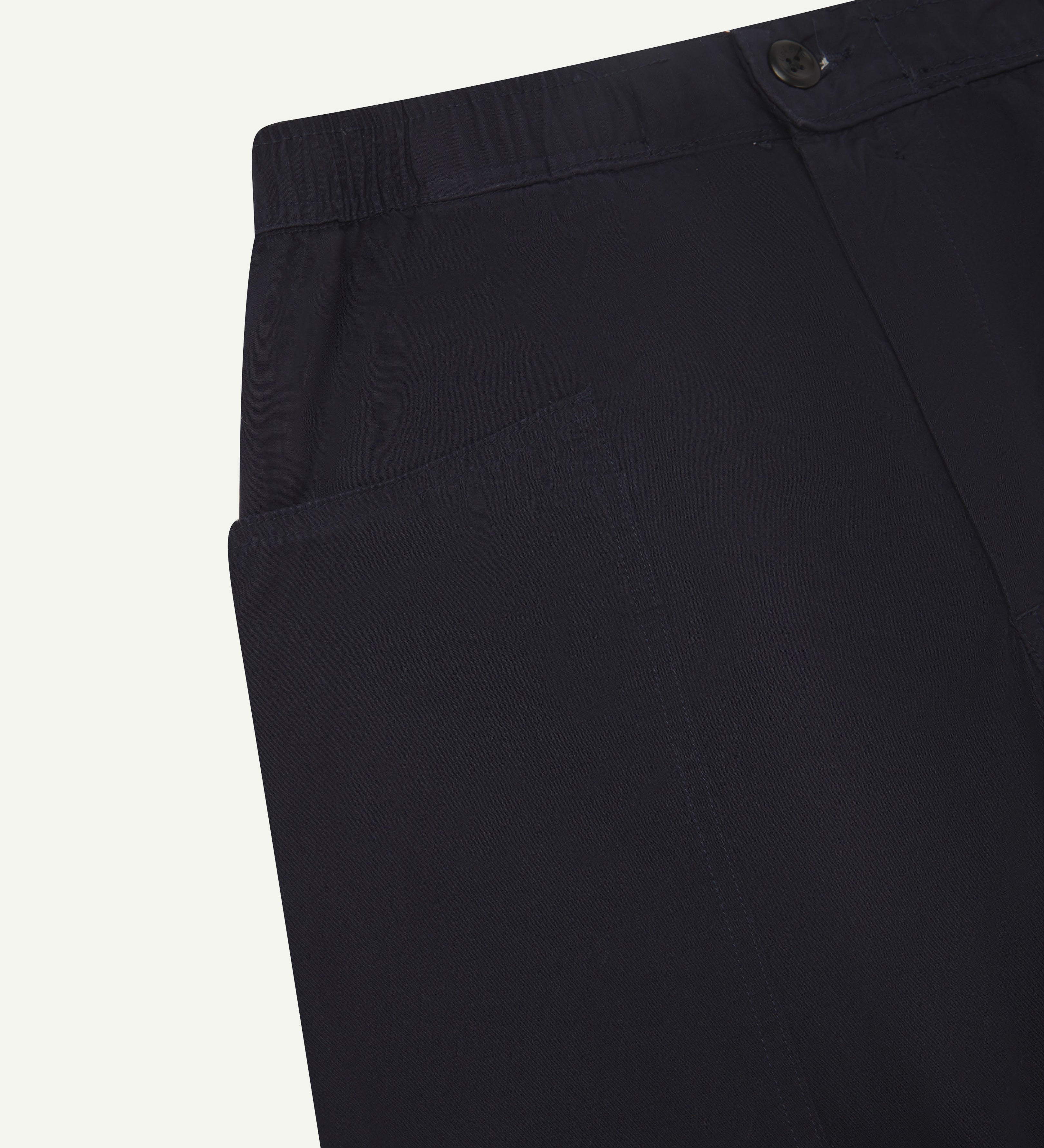 Close angled view of the elasticated waist and corozo button fastening of the midnight-blue #5011 Uskees pants.