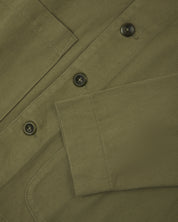 Front close view of moss green organic cotton drill commuter blazer showing cuff/sleeve, corozo buttons &  patch pocket