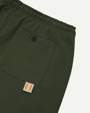 Back close view of organic cotton Joggers for men by Uskees showing the buttoned back pocket and logo label.