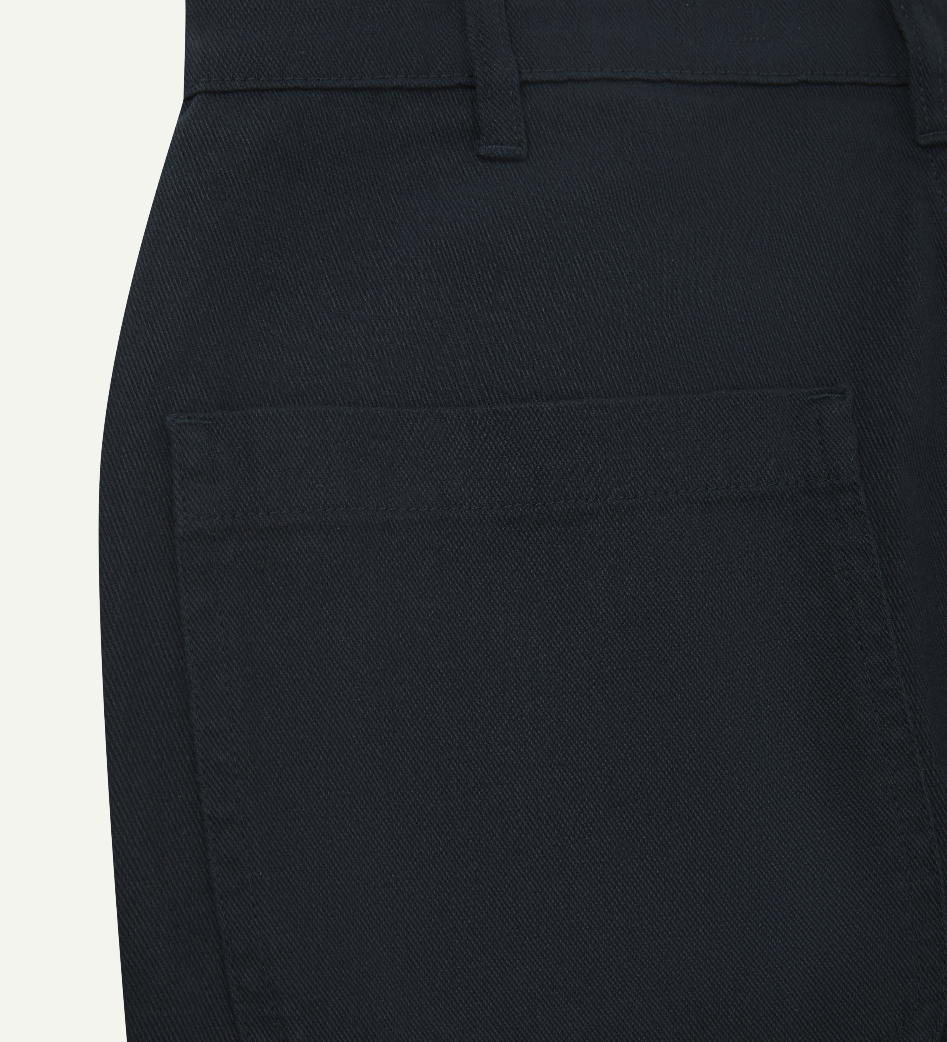Back close-up view of uskees cotton drill 'commuter' trousers for men in dark blue showing back pocket and belt loops.