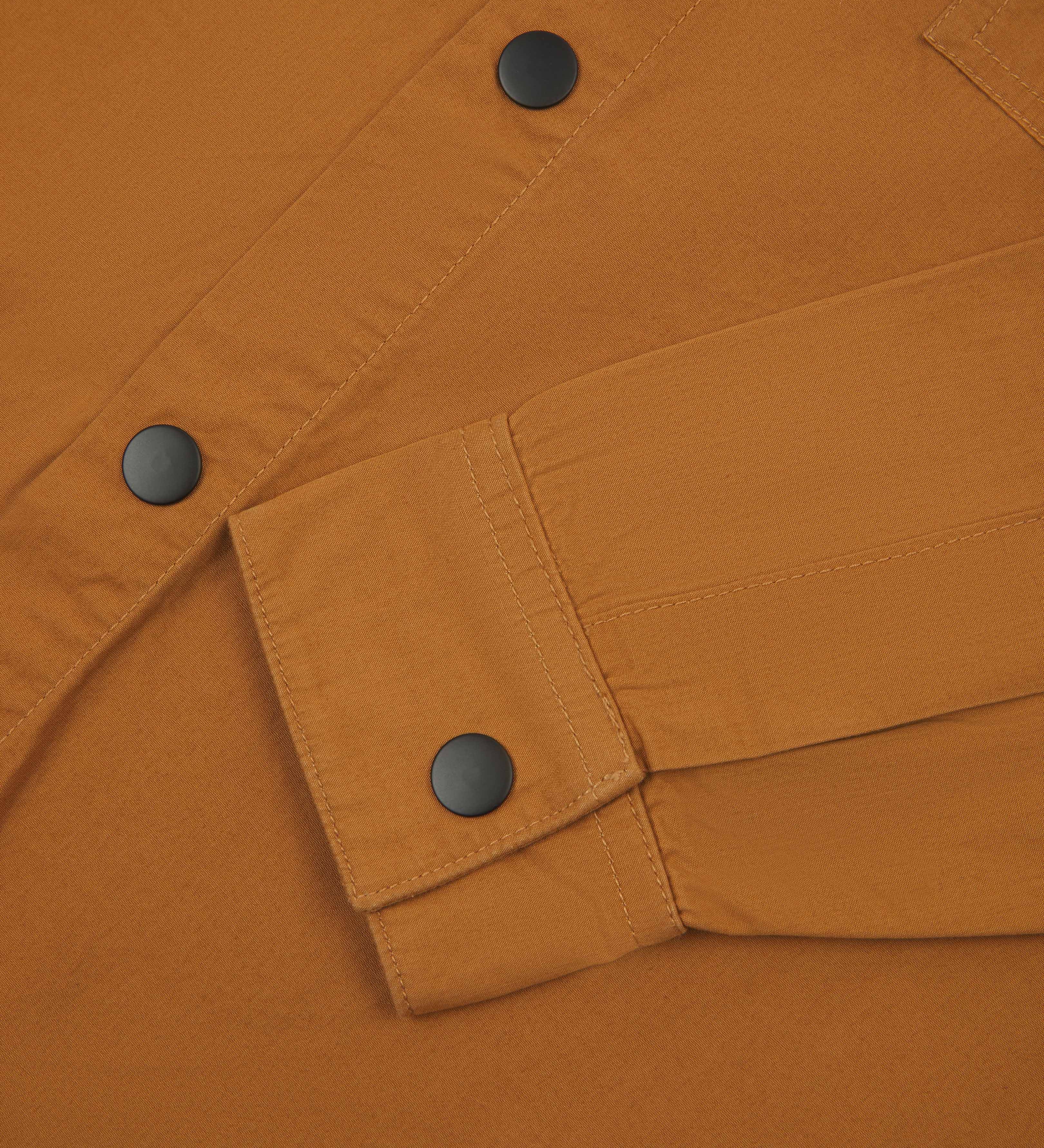  front flat shot of light brown uskees men's lightweight shirt with popper front and cuff fastening in close-up