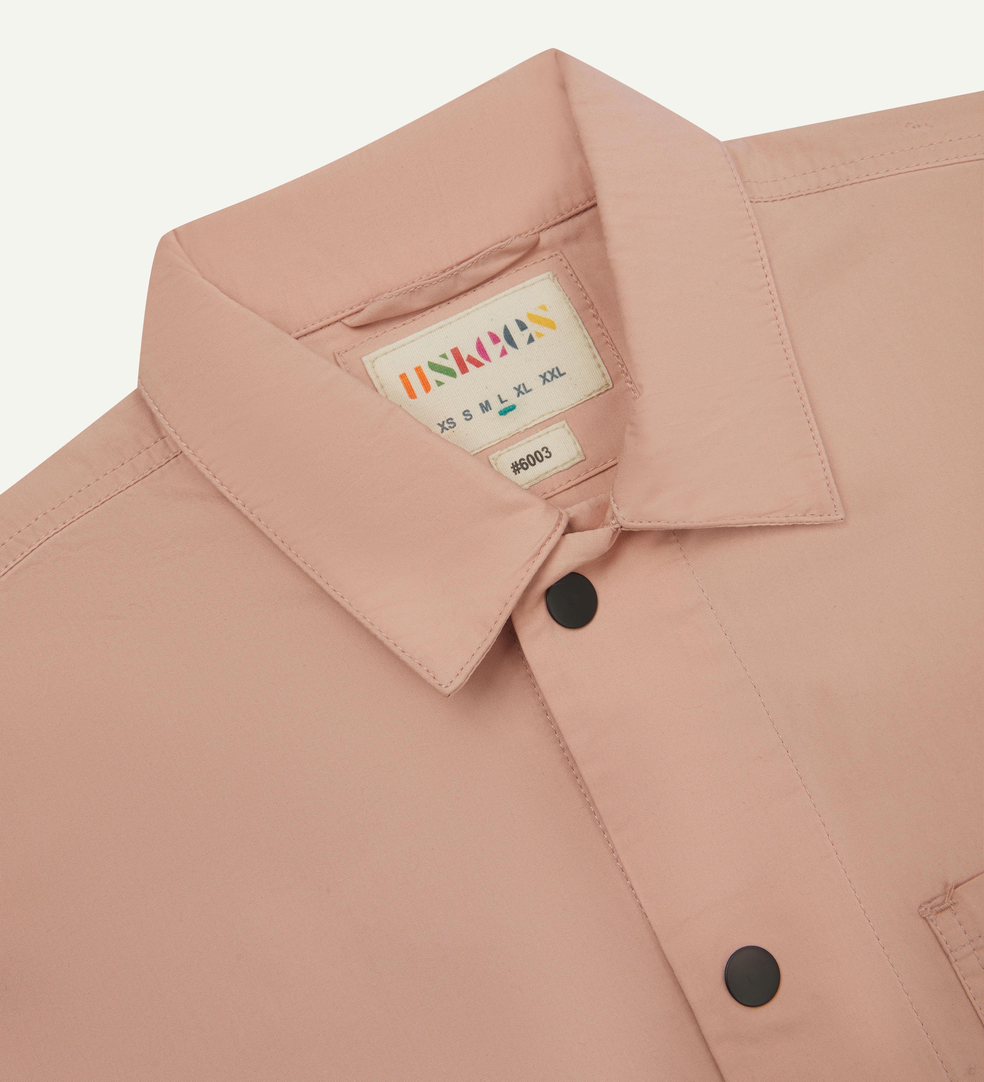close up shot of uskees dusty pink men's #6003 shirt showing collar and black popper detail