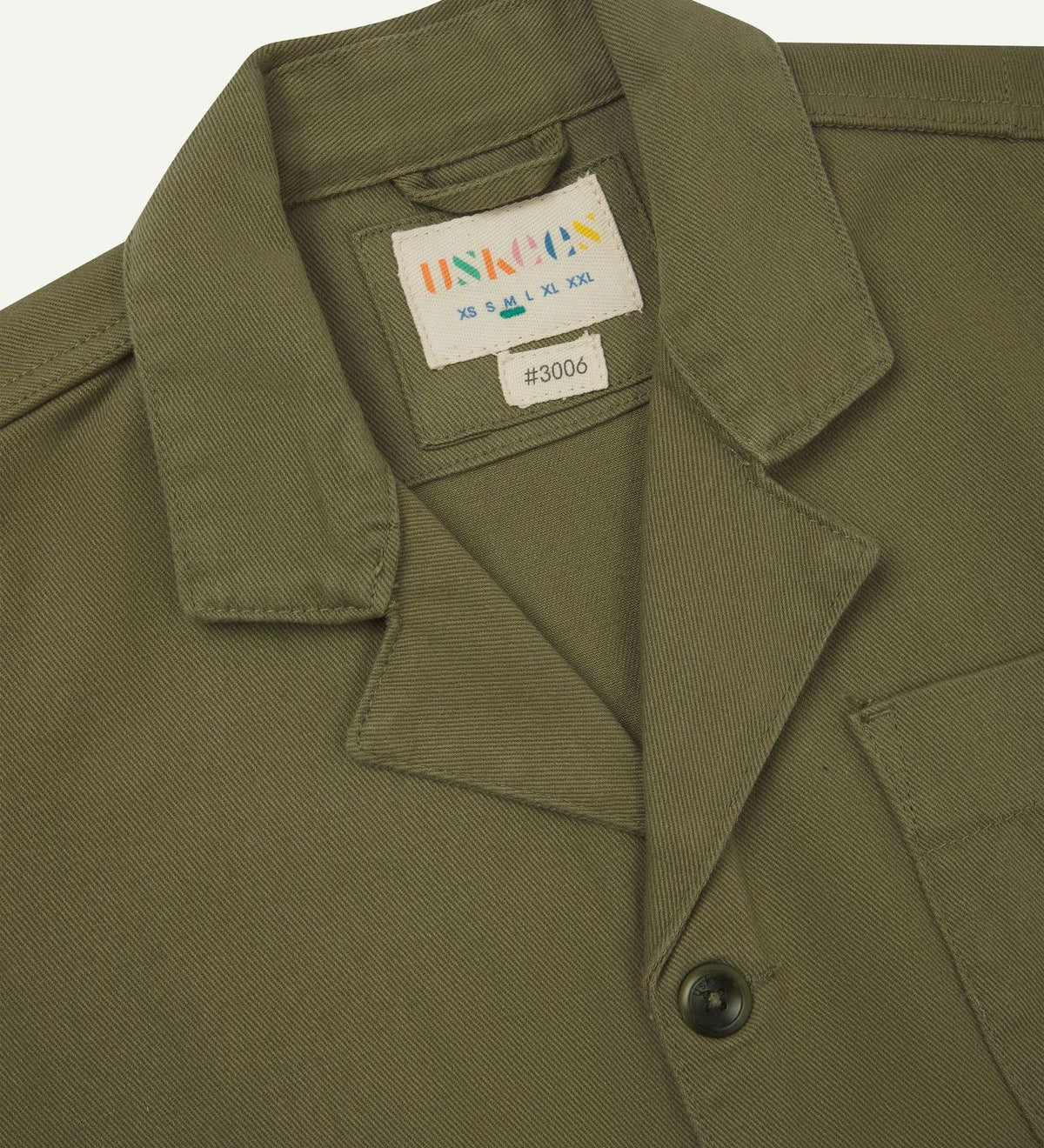 Close-up view of uskees moss-green organic cotton drill blazer showing collar and Uskees brand label