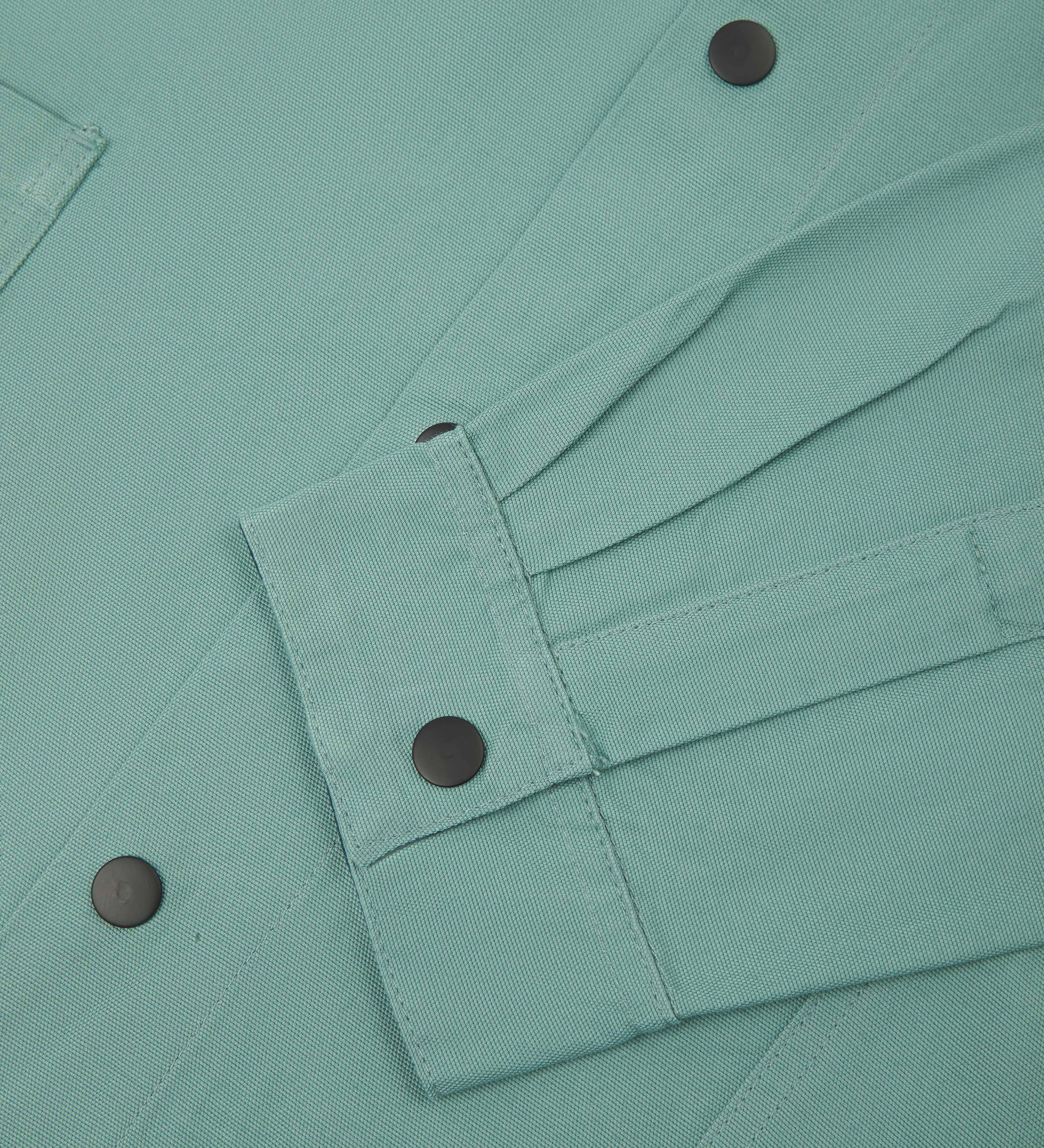 Close up view of Uskees eucalyptus organic cotton coach jacket showing sleeve and front popper fastenings 