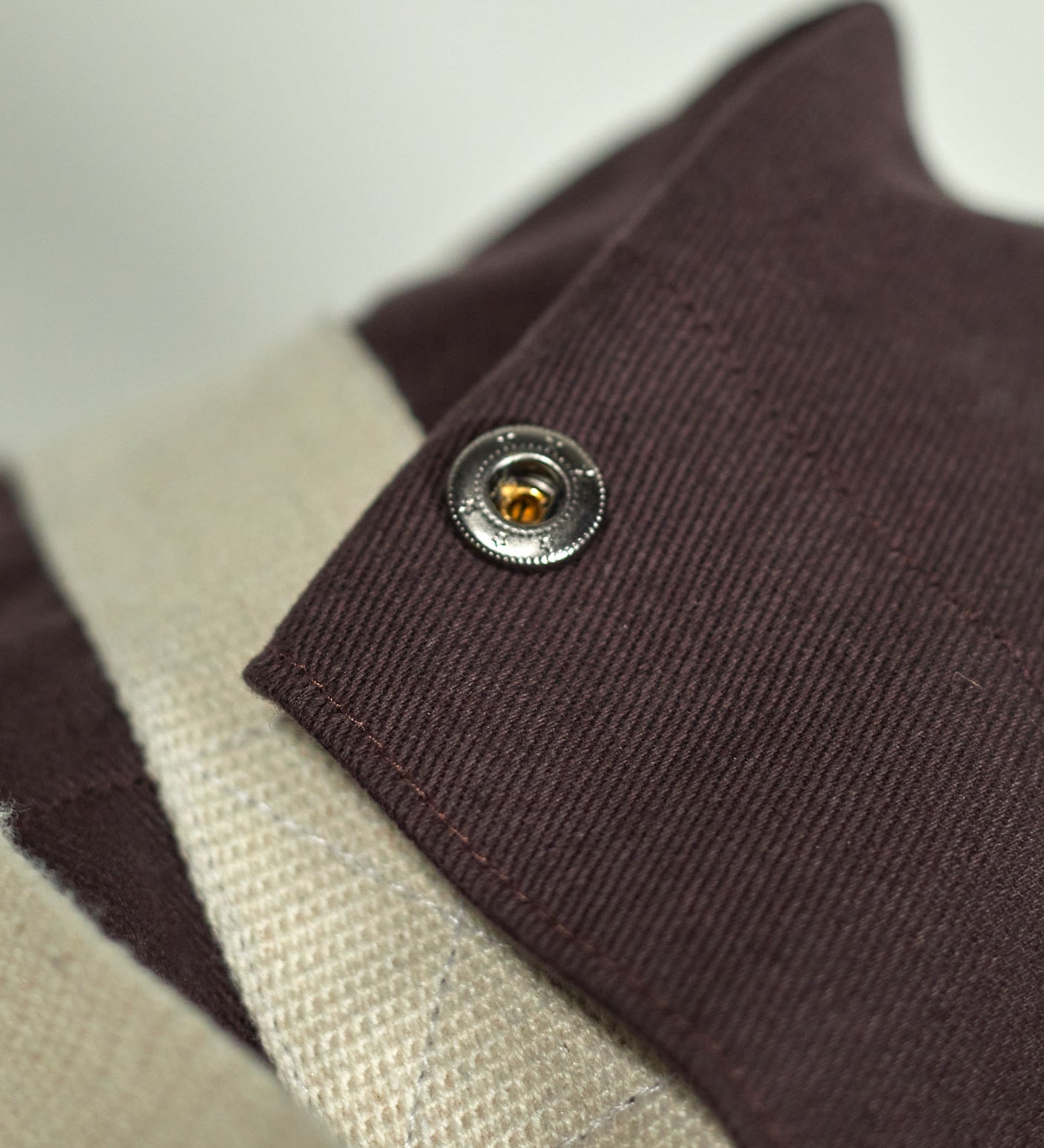 Press-stud fastenings to adjust the size of the cotton drill Uskees #0401 basin bag in dark plum.