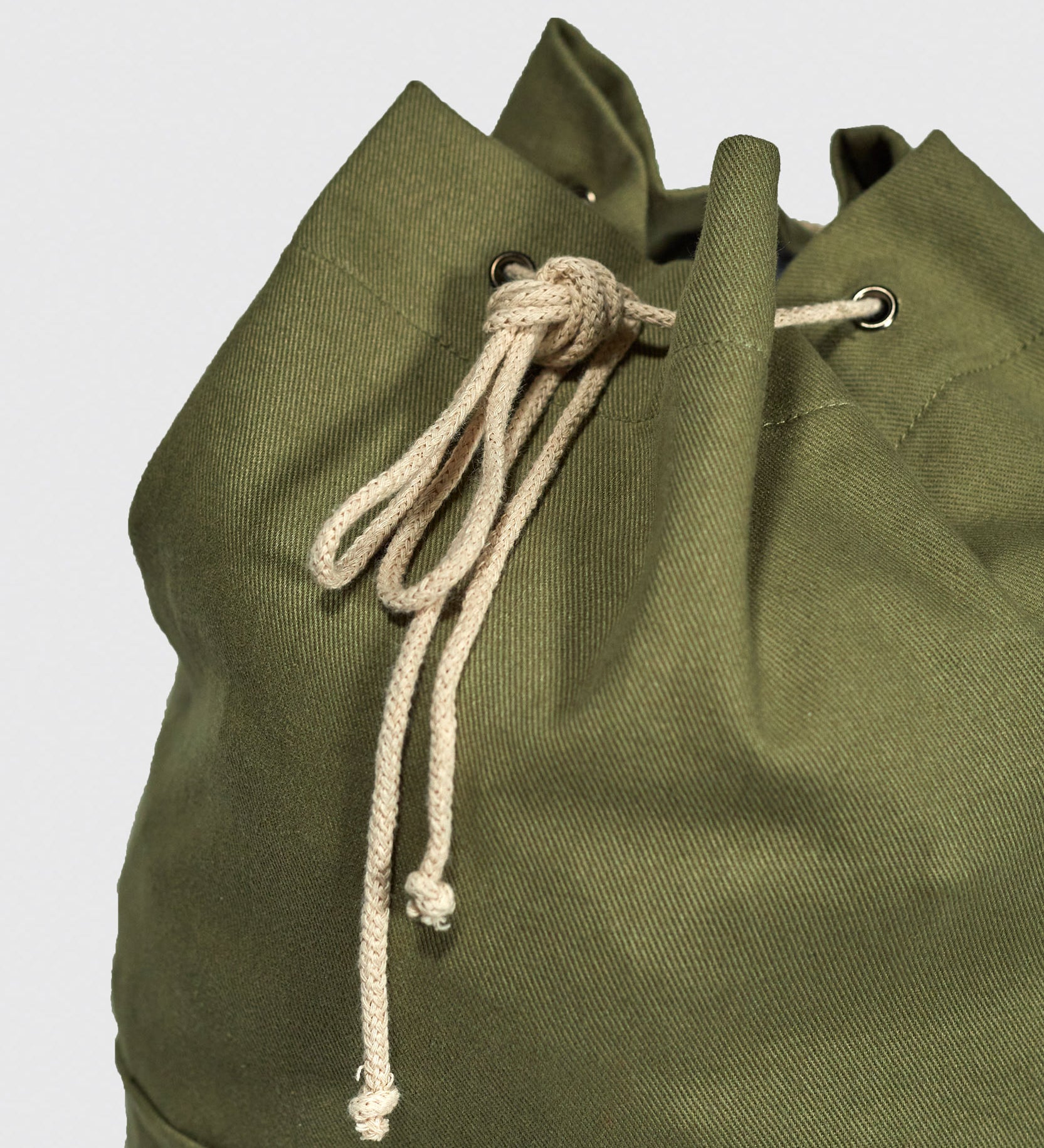 Closer view of the cream organic cotton drawstring on the moss green Uskees #0402 bucket bag.