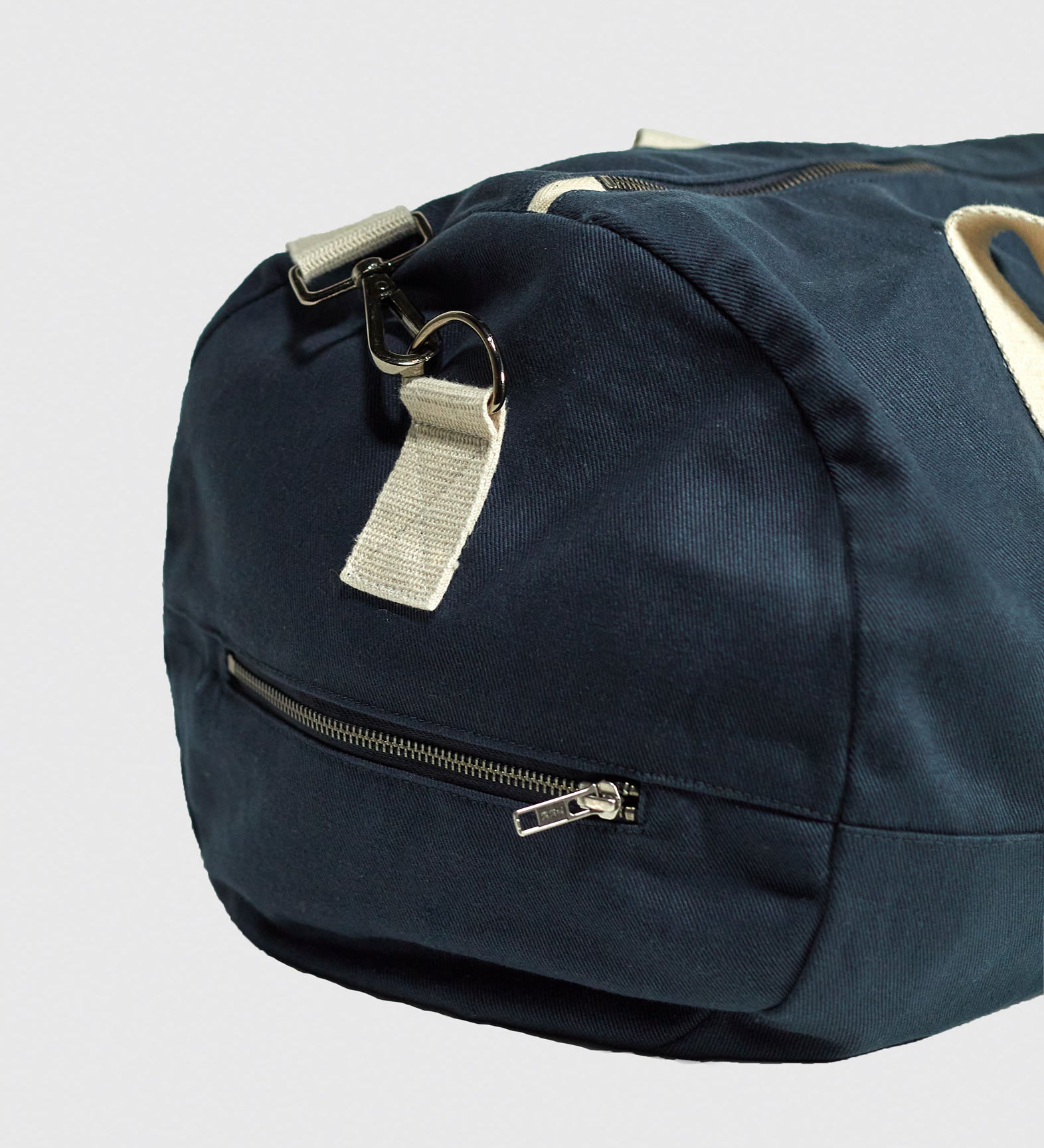 Focus on end of Uskees #0403 barrel bag in bluberry cotton drill, showing end zipper pocket and cotton webbing carry handle attachment.