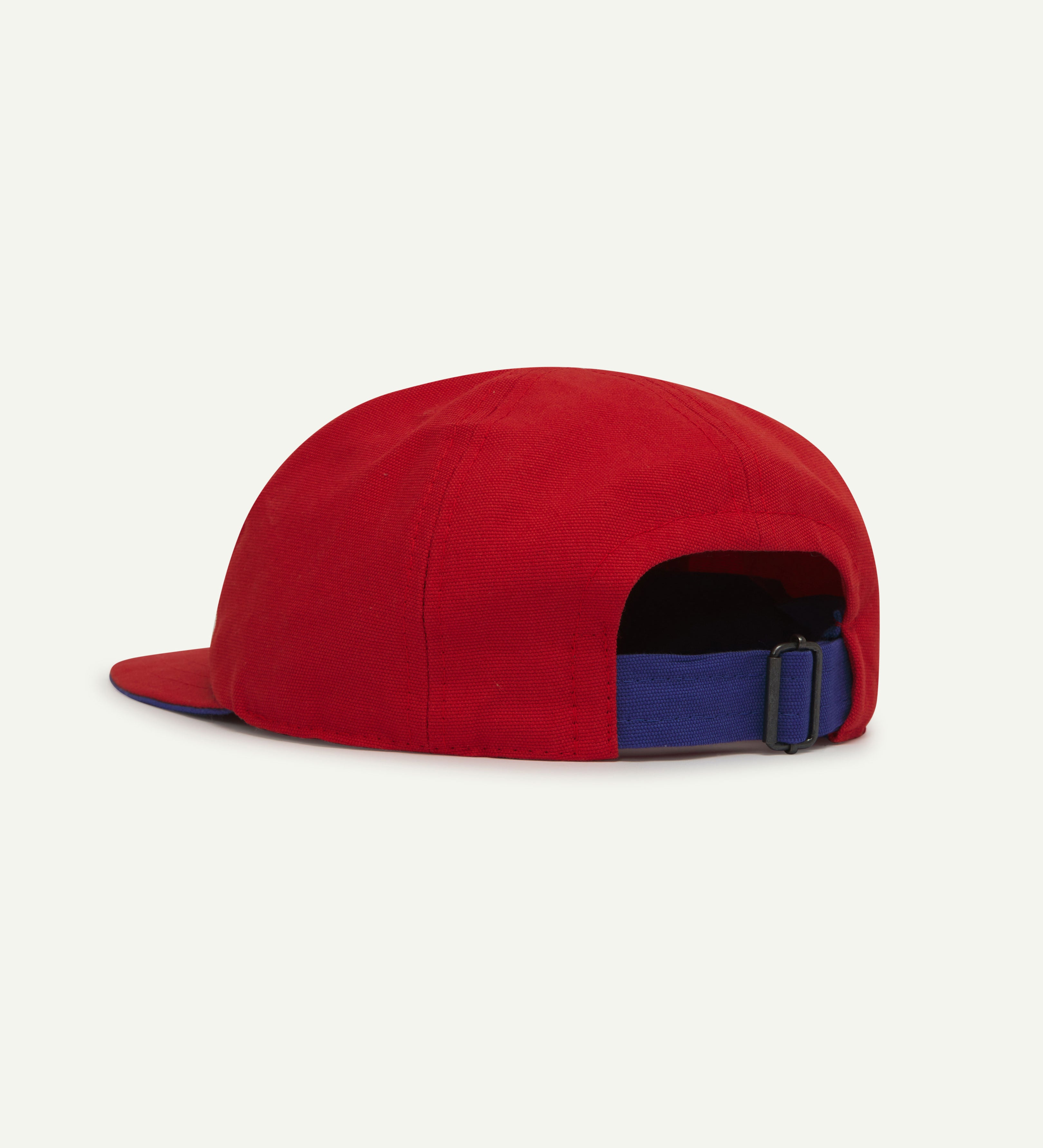 Angled back view of Uskees deadstock 6-panel cap in bright red showing contrast blue adjuster loop.