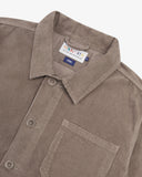 Close-up top-half view of #3001 beech (pale brown) organic cotton corduroy overshirt. With focus on collar, Uskees brand label and corozo buttons.