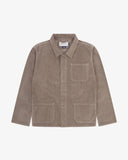 Front flat shot of beech (pale brown), buttoned corduroy overshirt. Clear view of corozo buttons, 3 pockets and Uskees branding label.
