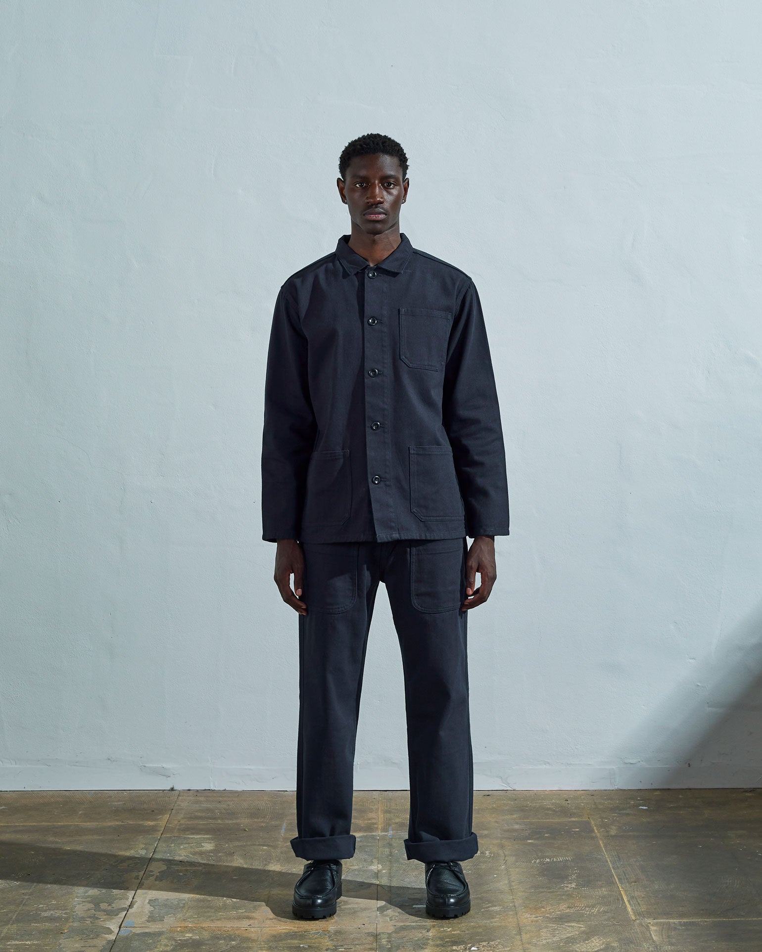Full-length front view of model wearing #3001 blueberry-coloured organic cotton-drill overshirt, showing secured corozo buttons and paired with matching Uskees pants.