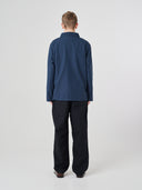 Full-length back view of man wearing an Uskees blueberry ripstop overshirt paired with dark pants, showing reinforced elbows.