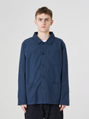 Top-half view of man wearing an Uskees blueberry ripstop overshirt indicating roomy, boxy fit with clear view of deep pockets on the chest and front.