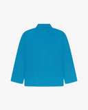 Back view of bright blue, buttoned organic cotton overshirt with view of reinforced elbow area and boxy silhouette.