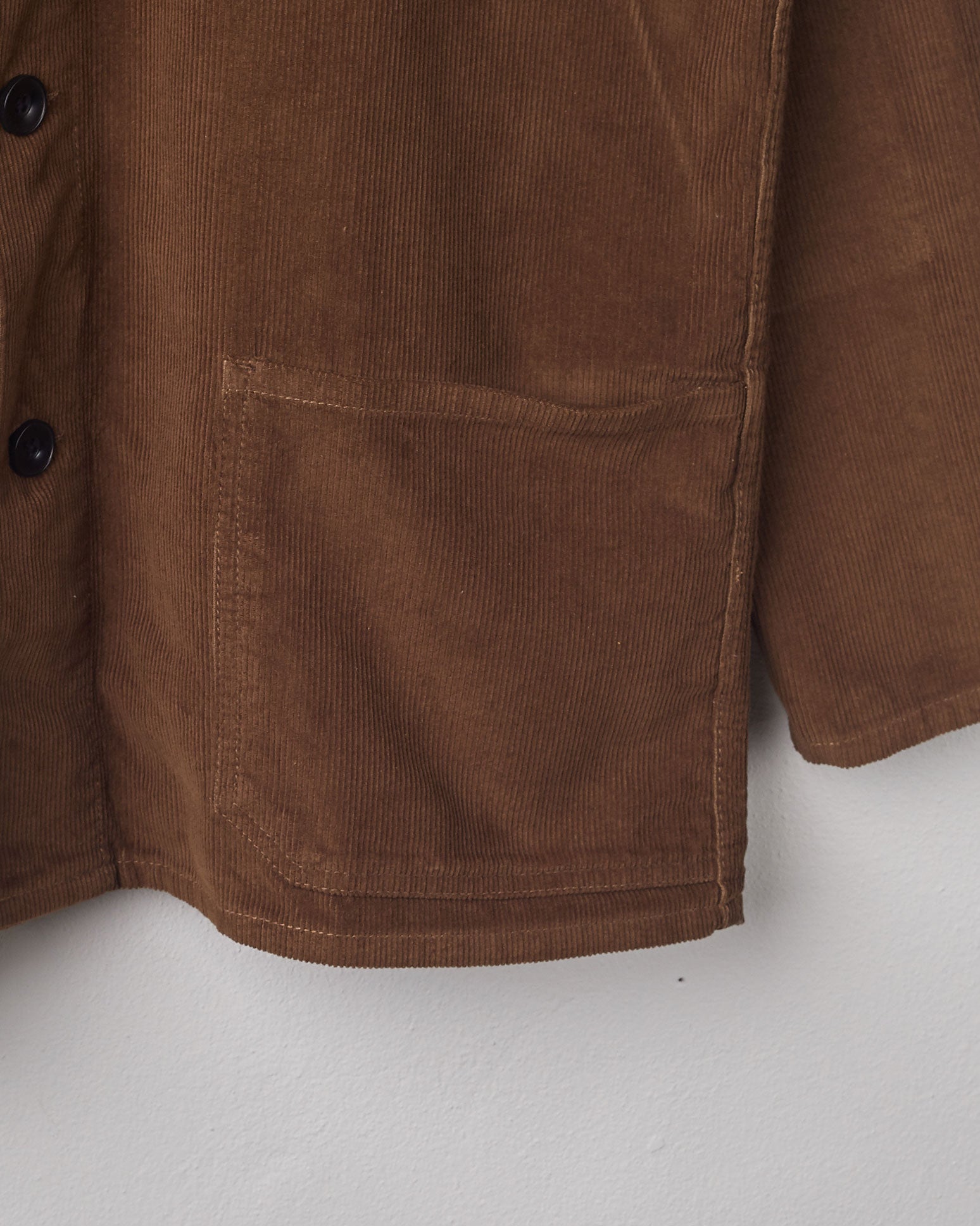 Close-up, bottom-left view of brown-coloured corduroy overshirt from Uskees with clear view of left hip pocket and sleeve.