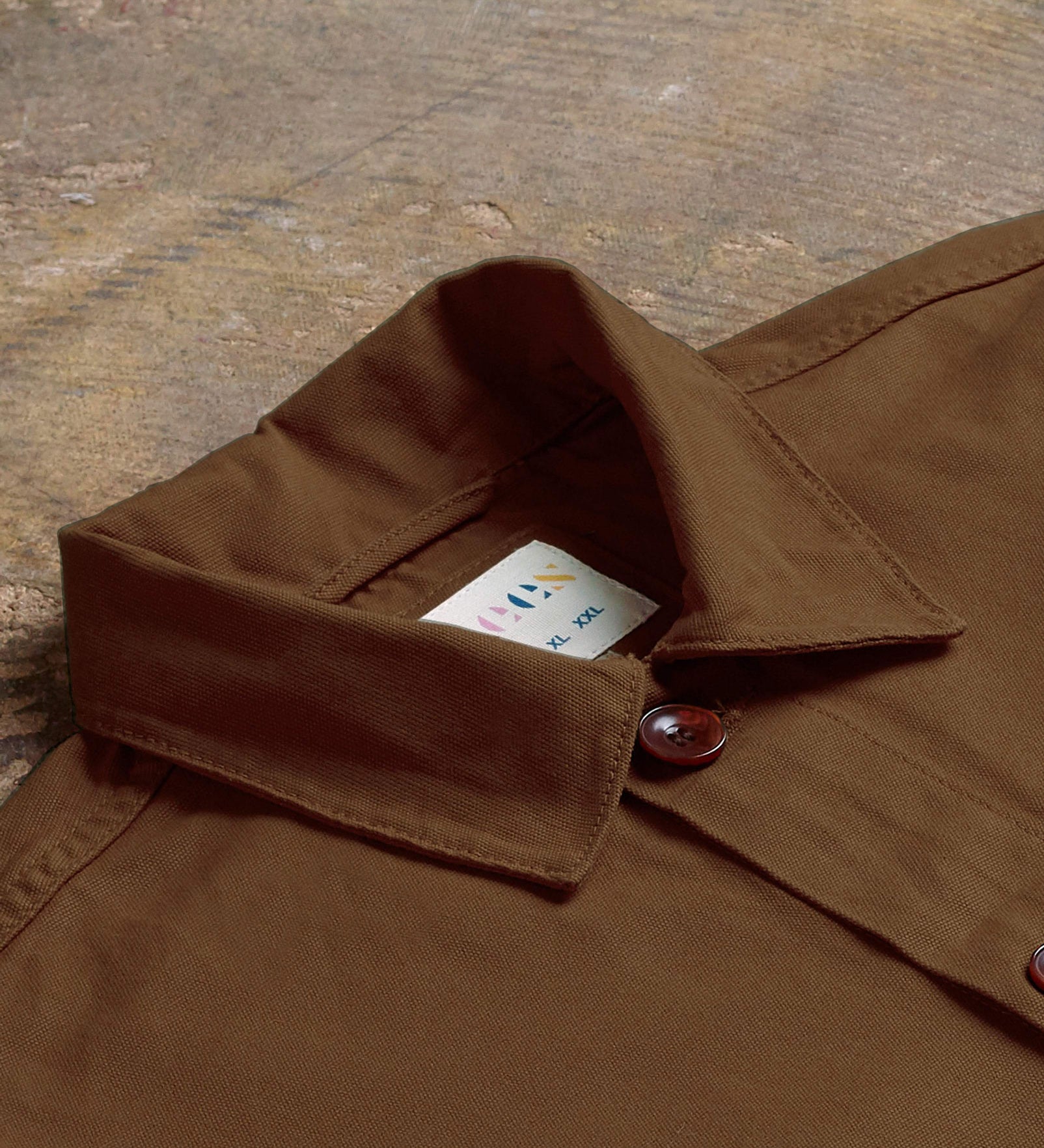 Angled flat view of the collar of the brown #3001 Uskees overshirt showing weave of organic cotton and Uskees branding label.