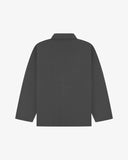 Reverse of charcoal-grey buttoned organic cotton drill overshirt from Uskees. Showing reinforced elbows and boxy silhouette.